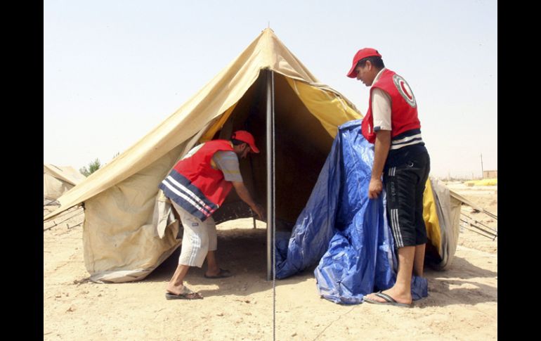 Voluntarios de la Media Luna Roja montan tiendas de campaña para alojar a los refugiados sirios. EFE  /