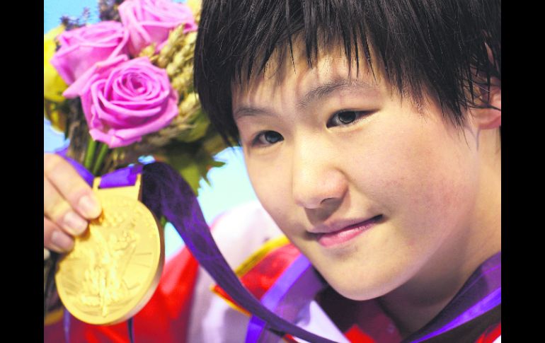 La china Shiwen Ye, de 16 años de edad, sostiene la medalla de oro que ganó en la prueba de 400 metros combinados. AP  /