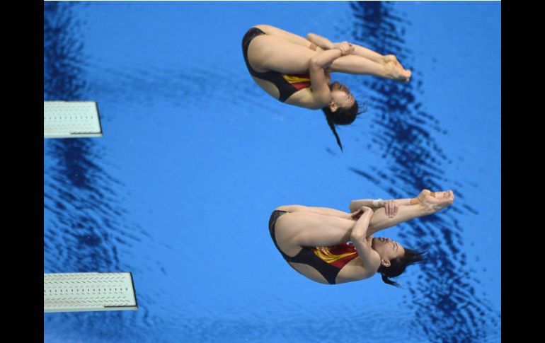 La pareja china sincronizada en uno de sus cinco saltos en la competencia. AFP  /