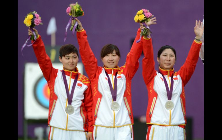 Cheng Ming (i), Fang Yuting (c) and Xu Jing (d) de China, festejan durante la ceremonia de premiación de Tiro con Arco. XINHUA  /