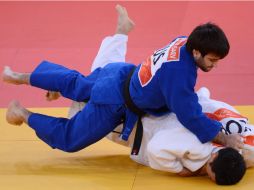 Mansur Isaev (azul) y Ki-Chun compiten en la final de judo varonil en la categoría de -73 kg. AFP  /