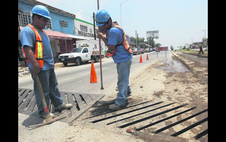 BOCA TAPADA. Personal del SIAPA desazolva una boca de tormenta en la Avenida 8 de Julio.  /