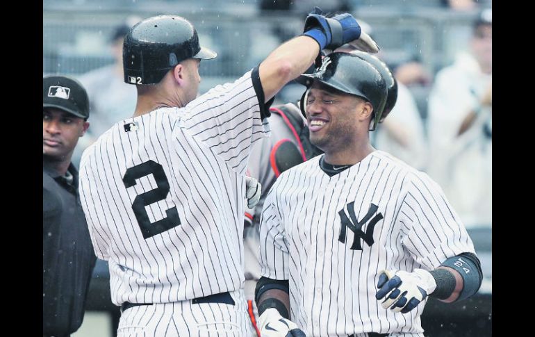 Sonrisas. Derek Jeter felicita a Robinson Canó tras su cuadrangular. AFP  /