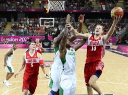 El jugador ruso Anton Ponkrashow inteneta encestar ante los brasileños Larry Taylor Y Nene Hilario. EFE  /