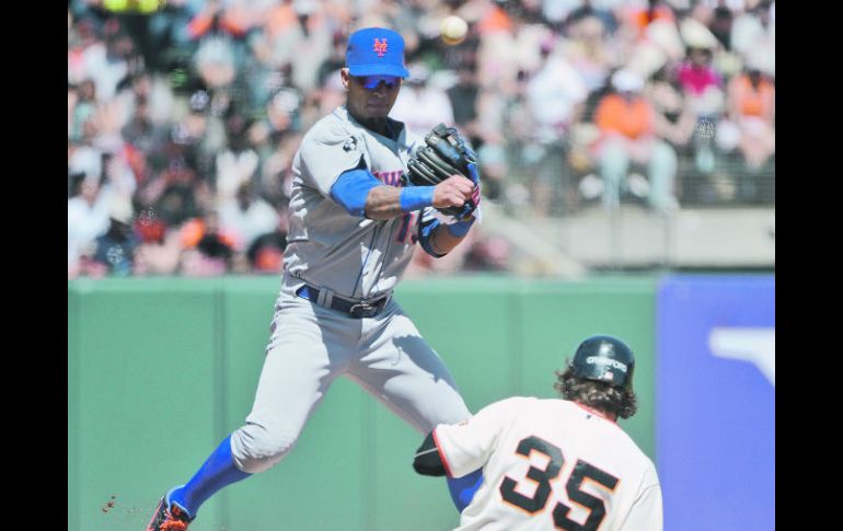 Ronny Cedeño completa el doble play al dejar fuera de acción a Brandon Crawford, de los Gigantes. AFP  /