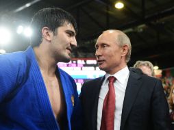 El presidente de Rusia, Valdimir Putin (D), conversa con el judoca Tagir Khaibulaev (I).  /