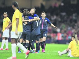 Las dos caras. Las jugadoras japonesas festejan el segundo gol, ante la tristeza de las brasileñas.  /