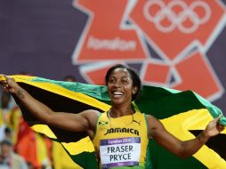 Fraser, de 25 años, festeja su triunfo portando la bandera de Jamaica con orgullo. AFP  /