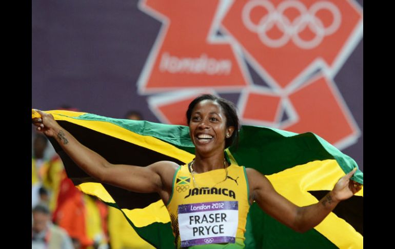 Fraser, de 25 años, festeja su triunfo portando la bandera de Jamaica con orgullo. AFP  /