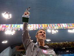 El nadador de EU sostiene un trofeo entregado por la FINA, al término de la final de relevo 4x100m combinado varonil. XINHUA  /