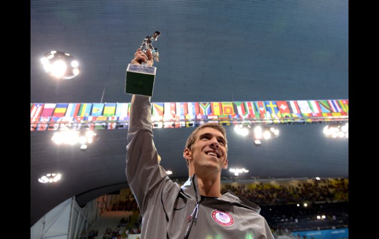 El nadador de EU sostiene un trofeo entregado por la FINA, al término de la final de relevo 4x100m combinado varonil. XINHUA  /