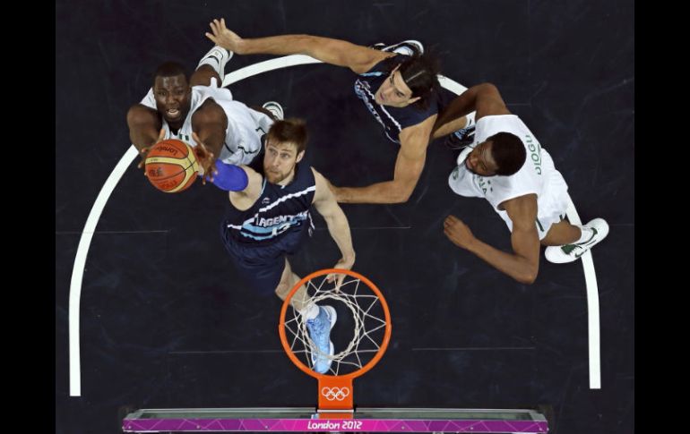 Olumide Oyedeji (I) toma el rebote de  Andres Nocioni (2I) y Luis Scola (2D) con Ike Diogu (D) mirando. REUTERS  /