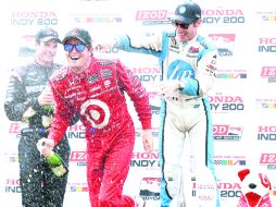 Baño. Scott Dixon recibe la rociada de champaña, por parte de Will Power. AFP  /