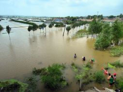 Habitantes caminan por las inundaciones que invadieron sus viviendas en la ciudad de Zhuanghe, noreste de China. EFE  /