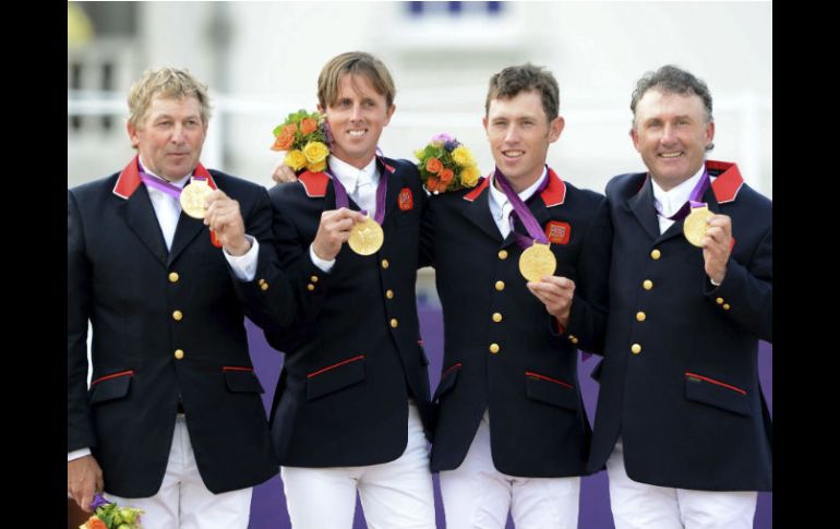 El equipo británico sonríe en el podio con medalla de oro. EFE  /