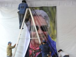 Hombres colocan una imagen de Chavela durante los preparativos para el homenaje en Plaza de Garibaldi. EFE  /