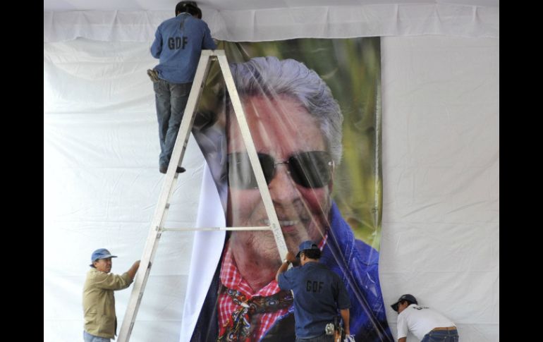 Hombres colocan una imagen de Chavela durante los preparativos para el homenaje en Plaza de Garibaldi. EFE  /