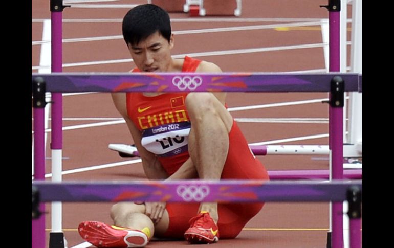 Liu Xiang, al momento de sufrir el golpe en la clasificación de los 100 metros con vallas. AP  /