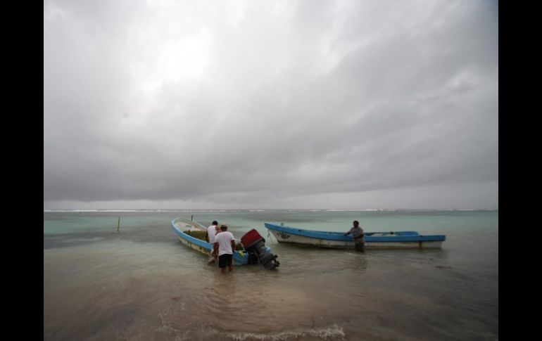 Pescadores de la comunidad de El Majahual, en Quintana Roo, protegen sus barcas en la zona donde impactará el huracán ''Ernesto''. EFE  /