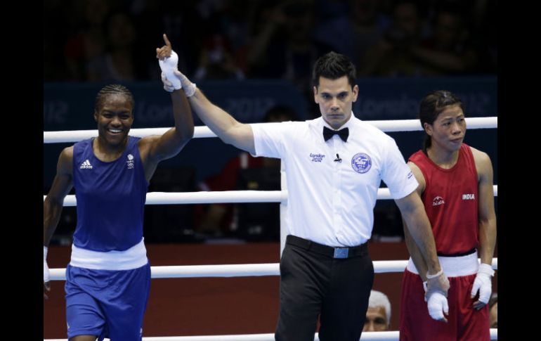 El réferi le levanta el brazo de ganadora a Nicola Adams (de azul). AP  /