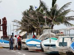 Pescadores sacan sus embarcaciones del mar para resguardarlas, en Veracruz, donde se espera que entre ''Ernesto. EL UNIVERSAL  /