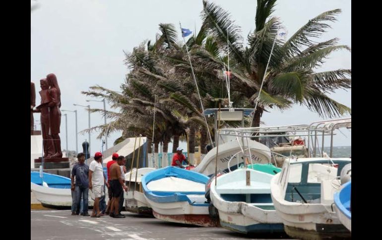 Pescadores sacan sus embarcaciones del mar para resguardarlas, en Veracruz, donde se espera que entre ''Ernesto. EL UNIVERSAL  /