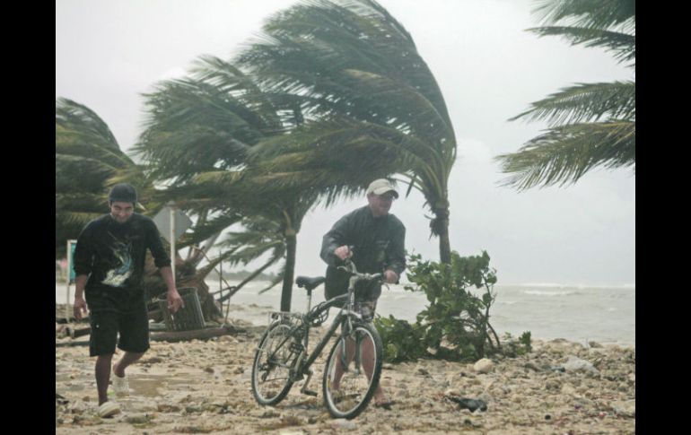 Un ciclista de la playa de Mahuahual, en Quintana Roo, optó por caminar ante las ráfagas del huracán “Ernesto”. REUTERS  /