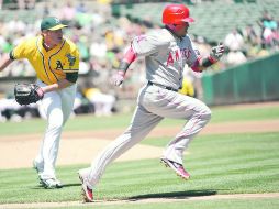 Córrele. Erick Aybar, de los Angelinos, corre a primera base, perseguido por el pitcher Dan Straily. AFP  /