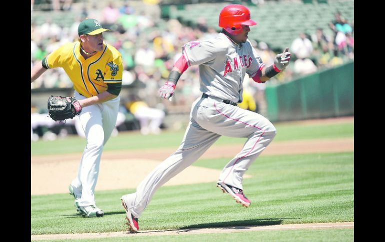 Córrele. Erick Aybar, de los Angelinos, corre a primera base, perseguido por el pitcher Dan Straily. AFP  /