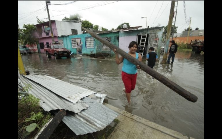 Pobladores de Huimanguillo, Tabasco, recuperan sus pertenencias en medio de la inundación. EFE EFE  /