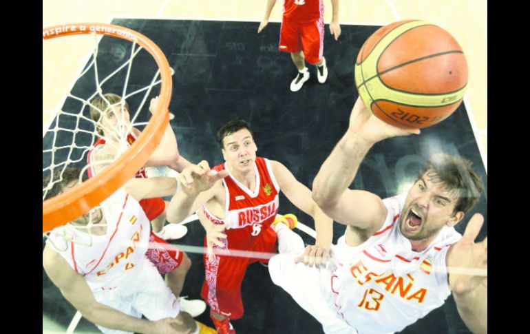 Marc Gasol (13) encesta una pelota ante la mirada del defensa ruso Sasha Kaun (8), que nada pudo hacer para evitar la anotación. AFP  /