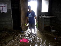 Un hombre entra a su casa después de ceder el flujo de agua. AP  /