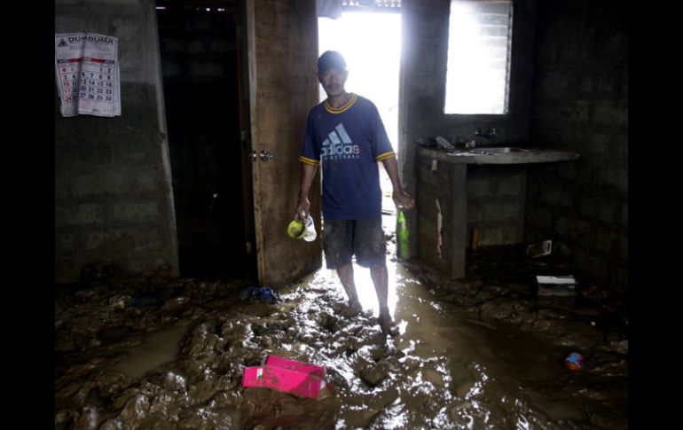 Un hombre entra a su casa después de ceder el flujo de agua. AP  /