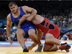 Flores (azul) durante el combate con el georgiano Davit Modzmanashvili. EFE  /