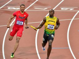 Bolt cierra a toda velocidad el relevo 4 por 100, alcanzándole para el récord mundial. AFP  /