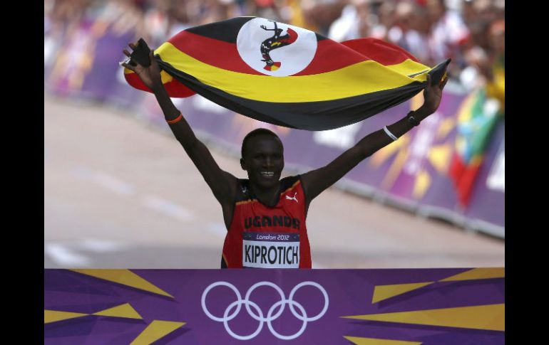 Kiprotich celebra en la meta del maratón olímpico, con una bandera de Uganda. REUTERS  /