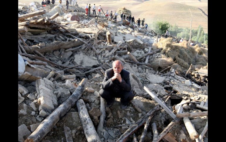 Un hombre se lamenta al observar el desatre que han dejado los terremotos en Irán. AFP  /