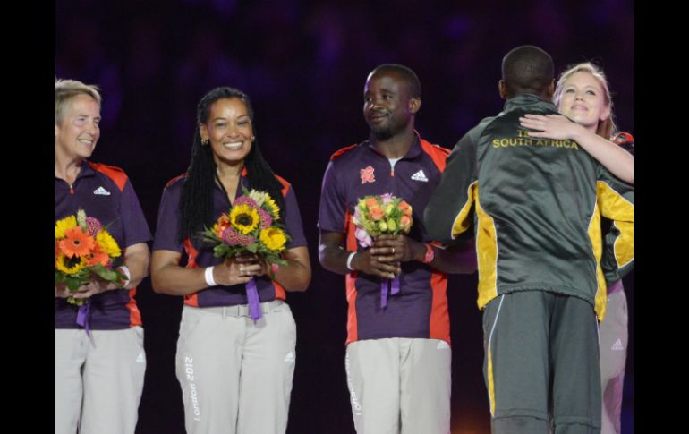 Voluntarios reciben galardones de parte de un atleta sudafricano. XINHUA  /