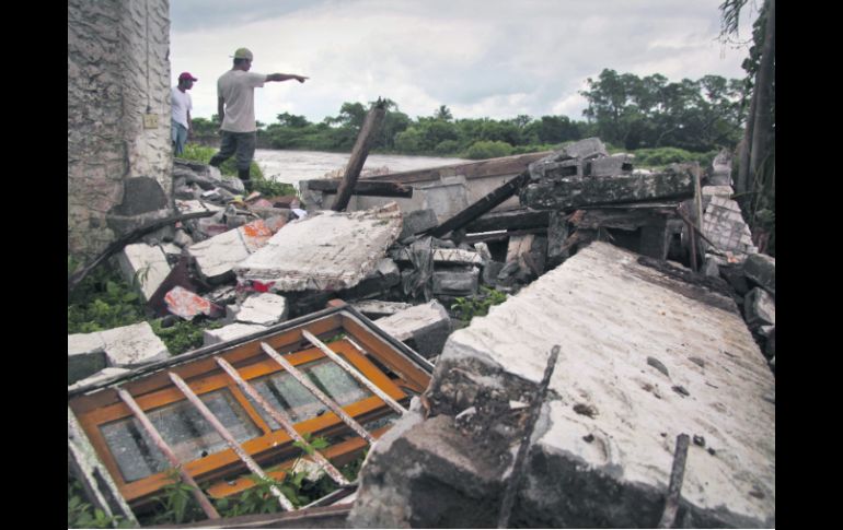 Daños notables. Habitantes de La Antigua, Veracruz, señalan los daños que dejó ''Ernesto'' en la población. AP  /