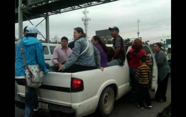 Ante la falta de unidades del transporte público, algunos conductores de camionetas ofrecen 'raite' en el Periférico Sur.  /