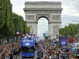 Los miembros del equipo olímpico francés pasean por los Campos Elíseos en París. EFE  /