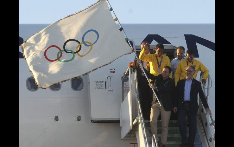 El alcalde de Rio, Eduardo Paes, descendió de un avión de Air France cargando la bandera olímpica. EFE  /