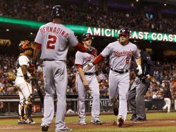 Danny Espinosa (d), de los Nacionales, es felicitado por Roger Bernardina (i) después de golpear un jonrón dos carreras. AFP  /