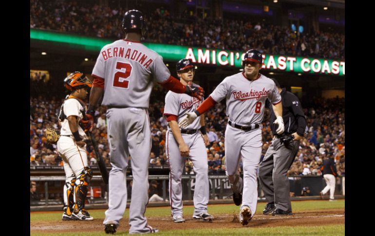 Danny Espinosa (d), de los Nacionales, es felicitado por Roger Bernardina (i) después de golpear un jonrón dos carreras. AFP  /