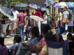 Los aplicantes hacen fila fuera de las oficinas para entregar su documentación. AP  /