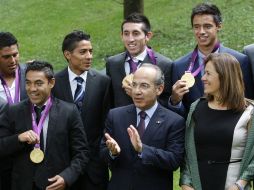 Héctor Herrera (detrás de Felipe Calderón) asistió ayer al homenaje a los medallistas en Los Pinos. EFE  /