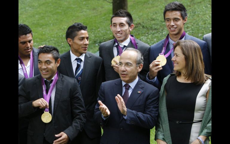 Héctor Herrera (detrás de Felipe Calderón) asistió ayer al homenaje a los medallistas en Los Pinos. EFE  /