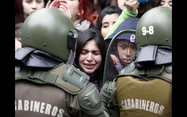 Una estudiante llora durante un enfrentamiento con la policía antidisturbios en una escuela de Santiago. REUTERS  /