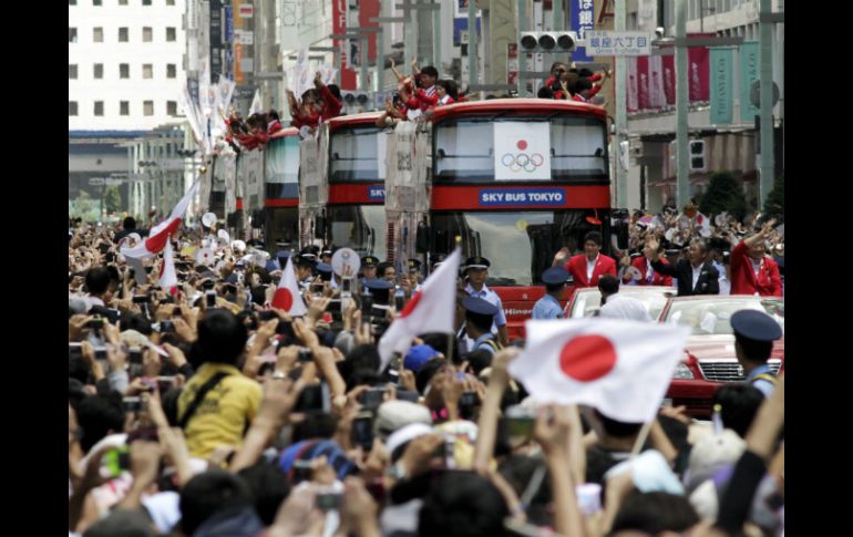 Cientos de personas reciben a los atletas japoneses que participaron en los Juegos Olímpicos Londres 2012. EFE  /