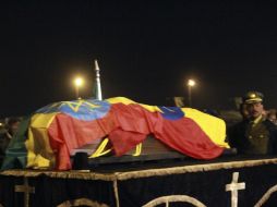 El ataúd, cubierto con la bandera etíope, fue bajado y  montado en un coche en la pista del aeropuerto, con guardia militar. AP  /